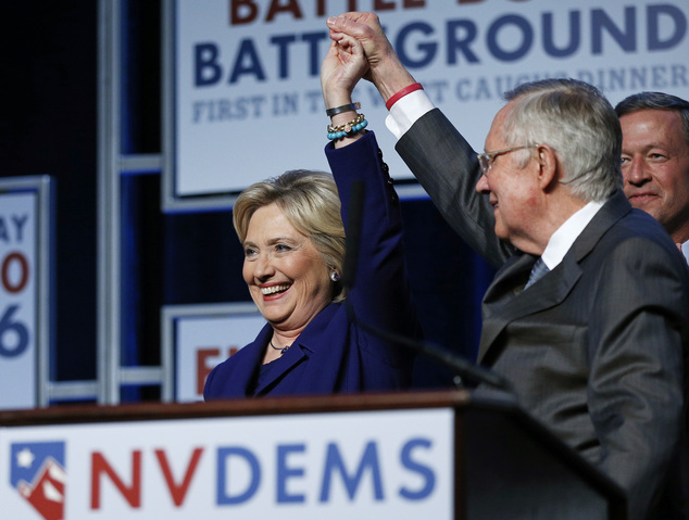 Senate Minority Leader Harry Reid D-Nev. holds up the hand of Democratic presidential candidate Hillary Clinton on stage at the Battle Born Battleground Fi