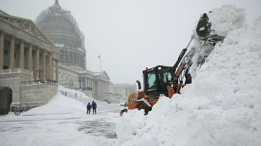 A bulldozer clears snow on the East Front of the U.S. Capitol on Saturday in Washington D.C