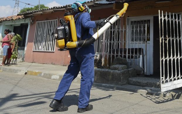 A health worker fumigates against the Aedes Aegypti mosquito in Cali Colombia