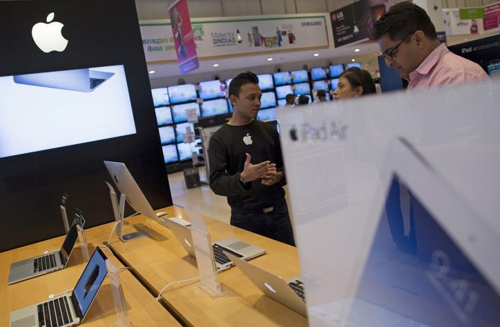 An Apple salesperson speaks to customers at a store in Mumbai India. Reuters  File