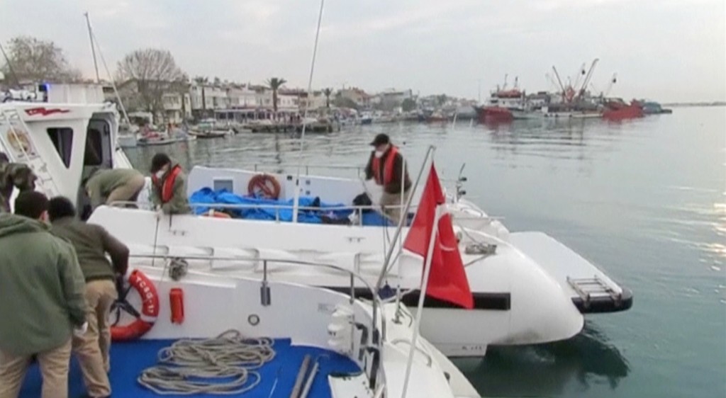 Coast guards carrying bodies of drowned migrants arrive at a port after a migrant boat sank off Turkey's western coast of Ayvacik in this still image from video taken