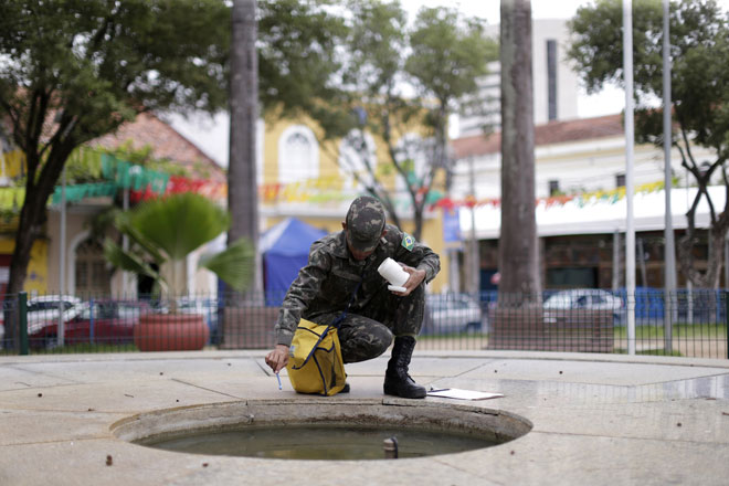 Brazilian soldiers conduct an inspection for the Aedes aegypti mosquito on a street in Recife Brazil. — Reuters