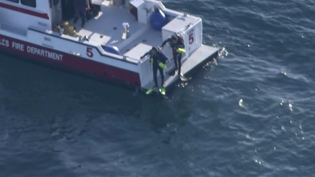 Divers enter the water off the L.A. harbor in the search for a possible downed plane on Feb. 5 2016