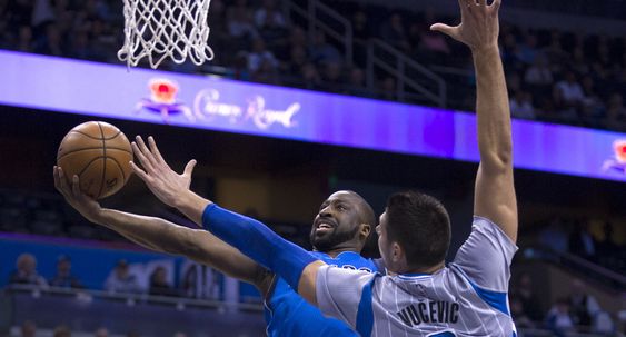 Raymond Felton left lays the ball up against Orlando Magic center Nikola Vucevic right during the first half of an NBA basketball game Friday Feb. 19 2016 in Orlando Fla