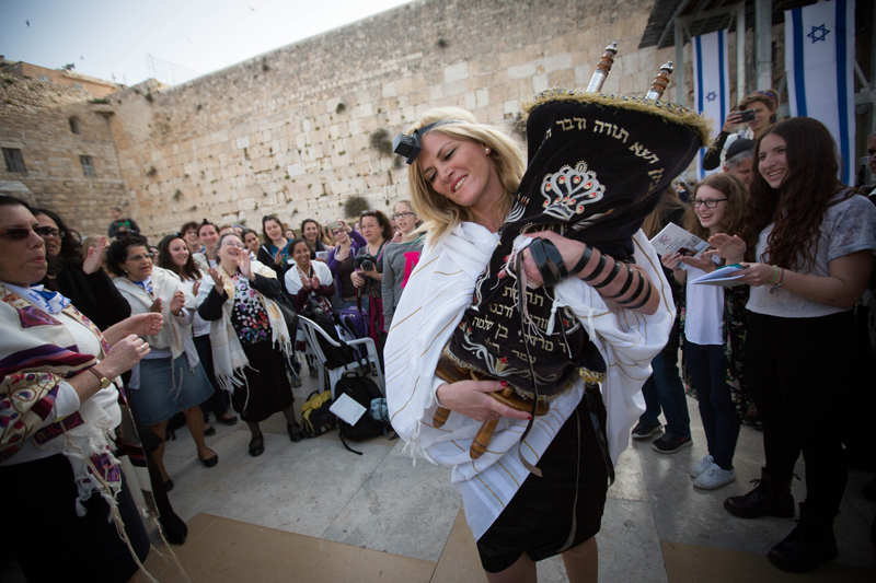 Women of the Wall who retrieved a Torah scroll from the men's prayer section despite regulations against women reading from a Torah at the Wall celebrate during their monthly prayer service at the Wall