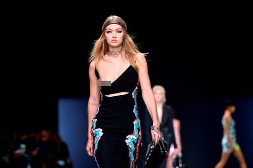 Model Gigi Hadid presents a creation for the show for fashion house Versace as part of the Women Autumn  Winter 2016 Milan Fashion Week