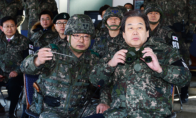 Saenuri Party Chairman Kim Moo-sung right listens to the commander of the 6th Infantry Division during his visit to a general post near the border in Cheorwon County Monday