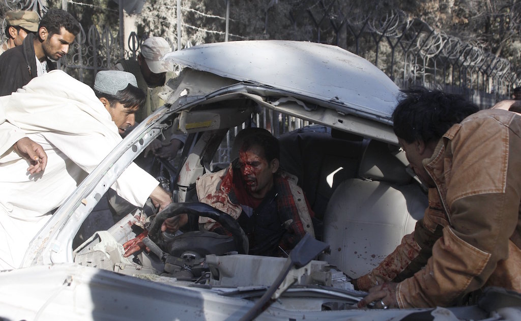 People help get an injured man out of his car after a blast in Quetta Pakistan