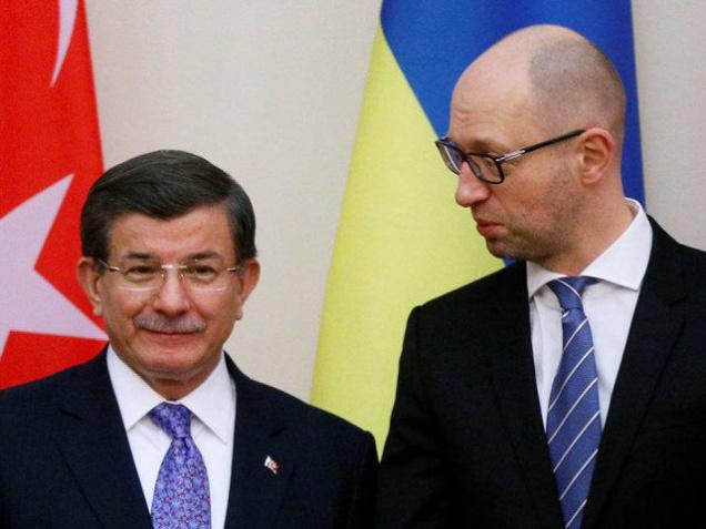 Ukraine's Prime Minister Arseny Yatseniuk speaks with his Turkish counterpart Ahmet Davutoglu during a signing ceremony in Kiev Ukraine