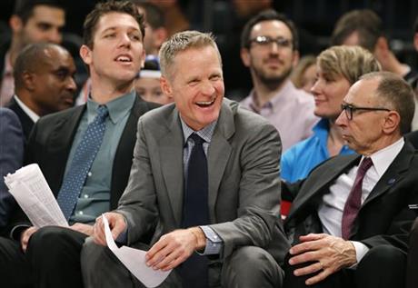 Golden State Warriors head coach Steve Kerr center laughs as he sits on the bench in the second half of an NBA basketball game against the New York Knicks at Madison Square Garden in New York Sunday Jan. 31 2016. The Warriors defeated the Knicks 116