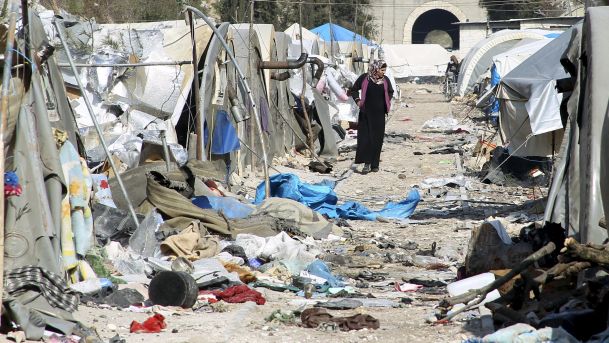 A woman inspects damage at a camp for IDPs after it was hit by what residents said was shelling carried out by Assad forces near the Syria Turkey border Jan. 31 2016