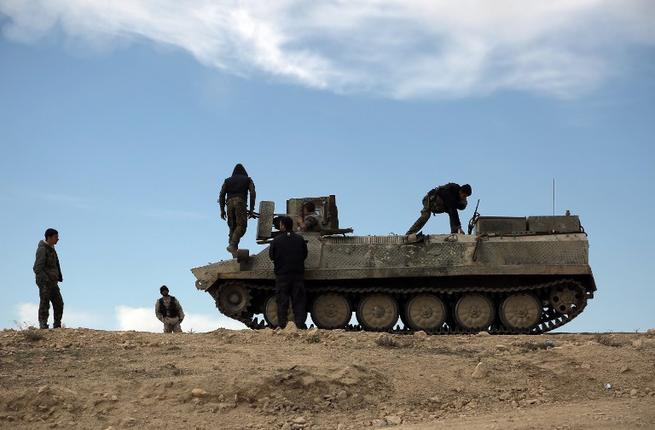 Fighters from the Syrian Democratic Forces sit atop an armored personnel carrier in the northeastern Syrian province of Hasakeh