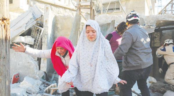 Two Syrian girls rush in panic after an air raid carried out by the regime on an area in northern Aleppo yesterday