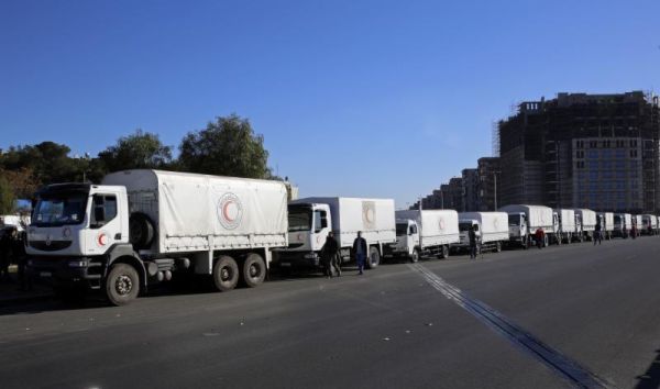 A convoy of humanitarian aid waits in front