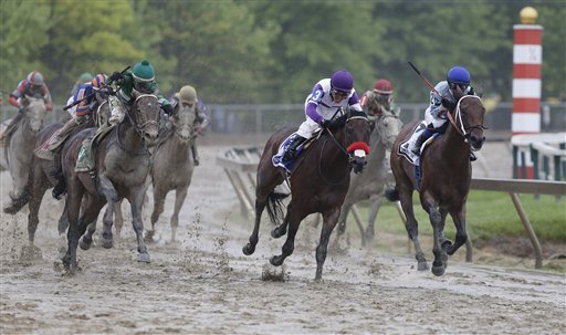 Exaggerator left with Kent Desormeaux aboard moves up on Nyquist with Mario Gutierrez aboard during the 141st Preakness Stakes horse race at Pimlico Race Course Saturday