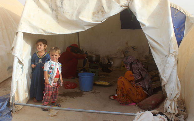 Displaced Iraqis from the embattled city of Fallujah cook at a camp where they are taking shelter some 18 kilometres from Ramadi