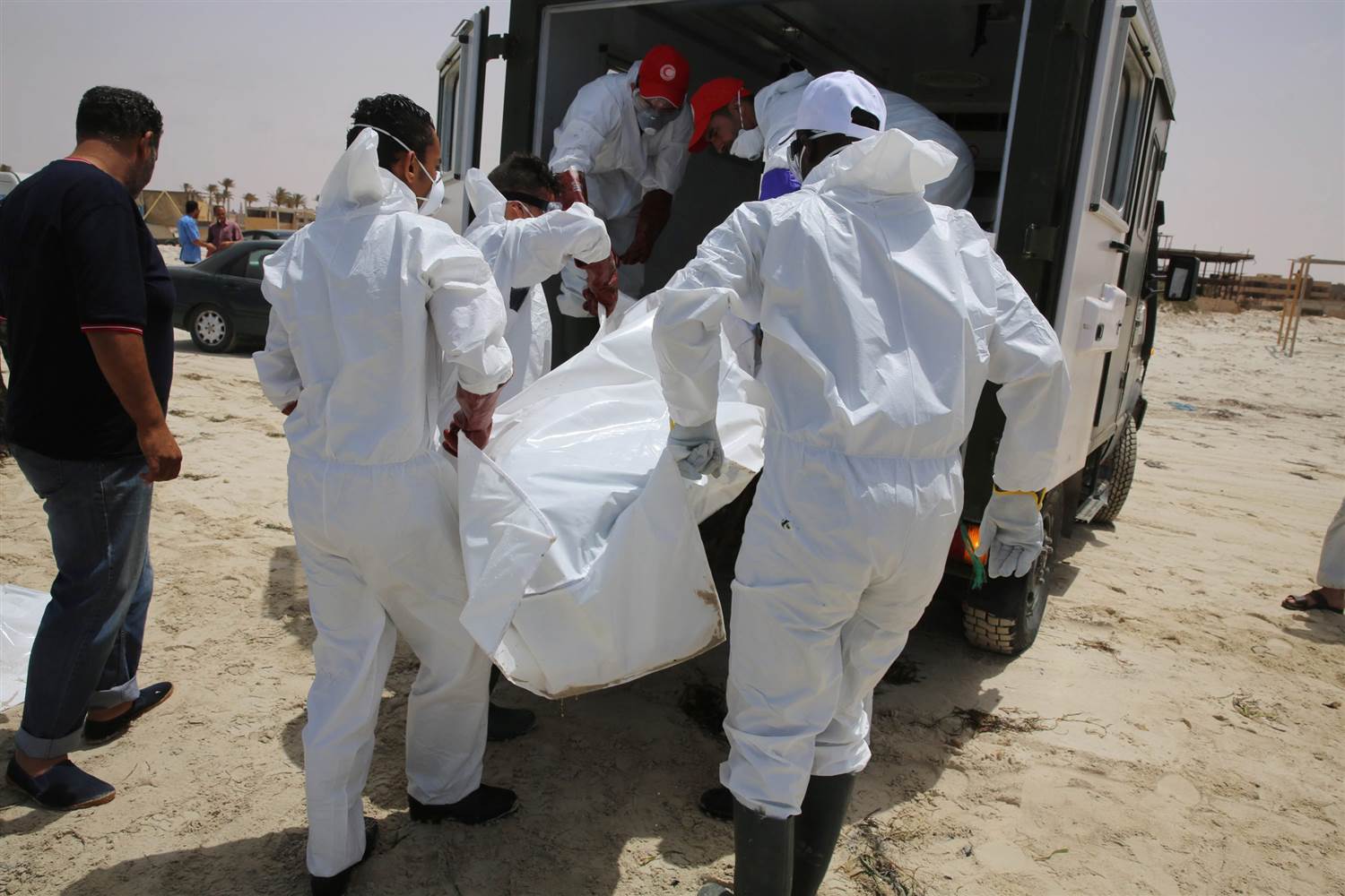 Image Libyan officials remove a body from a beach