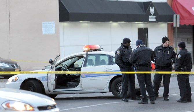 Baltimore police officers stand near a crime scene