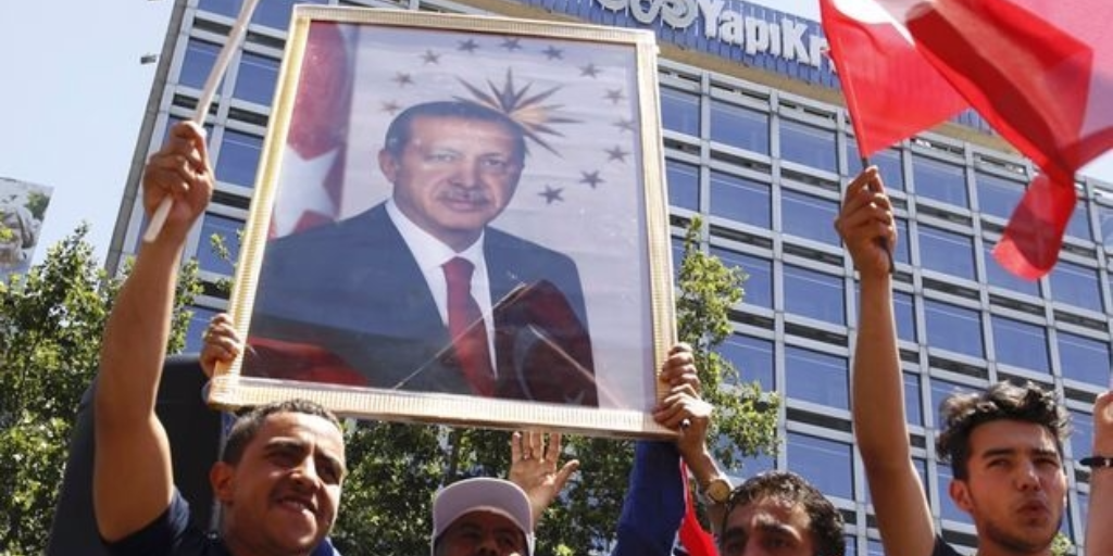 Supporters of Tukish President Tayyip Erdogan lift up his portrait as they celebrate with flags in Ankara Turkey. TUMAY BERKIN  REUTERS