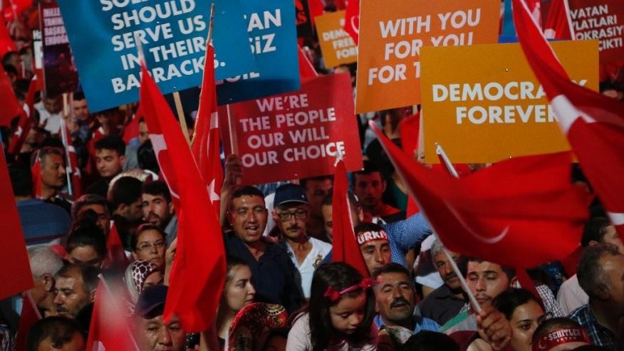 Supporters of Turkish President Recep Tayyip Erdogan hold banners and waves their national flags during a rally at Kizilay main square in Ankara Turkey Wednesday