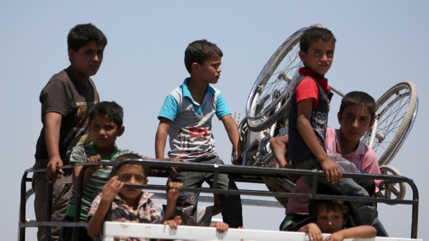 Boys on a pick-up truck evacuate from the southern districts of Manbij city after the Syria Democratic Forces fighters advanced into it on July 1. Airstrikes on the ISIS stronghold have killed scores of civilians including children rights groups allege