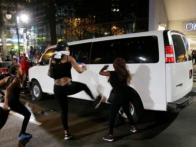 Demonstrators protest Tuesday's fatal police shooting of Keith Lamont Scott in Charlotte N.C. on Wednesday Sept. 21 2016. Protesters rushed police in riot gear at a downtown Charlotte hotel and officers have fired tear gas to disperse the crowd. A