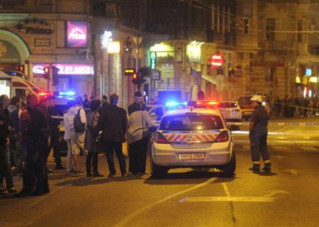 Police officers cordon off the area of the scene in central Budapest Hungary early Sunday Sept. 25 2016 after an explosion of yet unknown origin occured in a shop late Saturday night injuring two patrolling policemen