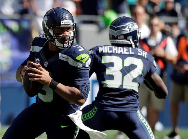 Seattle Seahawks quarterback Russell Wilson left drops to pass against the Miami Dolphins in the first half of an NFL football game in Seattle. Wilson insists he'll be ready to play against the Los