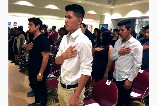 Long Chi Vong 16 center from Albuquerque and other immigrants stand for the U.S. Pledge of Allegiance before taking the Oath of Citizenship at a ceremony in Rio Rancho N.M. San Francisco 49ers quarterback Colin Kaepe