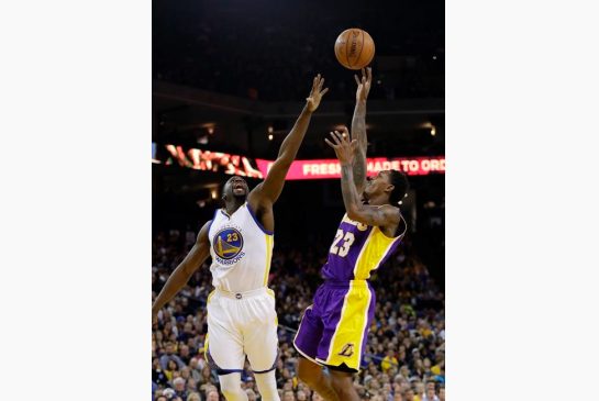 Los Angeles Lakers Lou Williams right shoots over Golden State Warriors Draymond Green during the first half of an NBA basketball game Wednesday Nov. 23 2016 in Oakland Calif