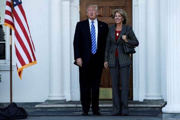 U.S. President-elect Donald Trump stands with Betsy De Vos after their meeting at the main clubhouse at Trump National Golf Club in Bedminster New Jersey U.S