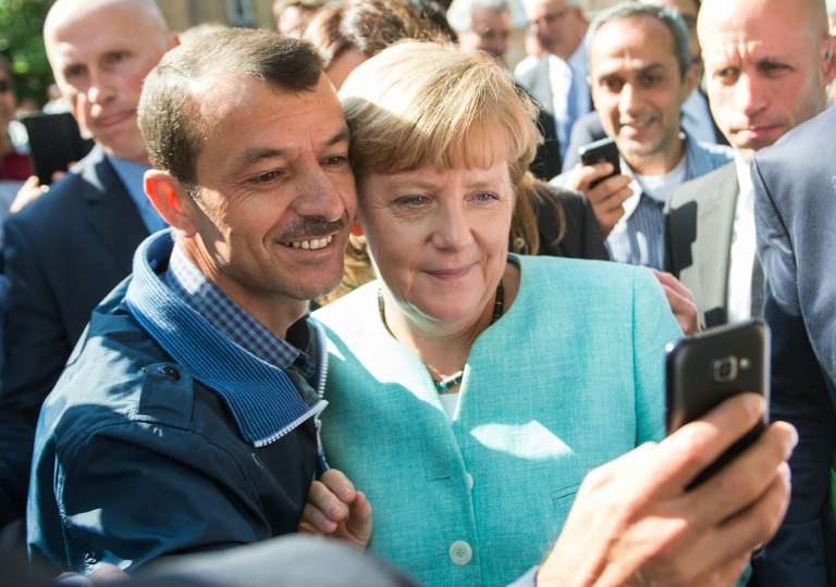 An asylum seeker takes a selfie with Angela Merkel in Berlin