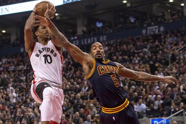 Cleveland Cavaliers guard J.R. Smith tries to stop Toronto Raptors guard De Mar DeRozan drives to the basket during first half NBA basketball action in Toronto on Monday