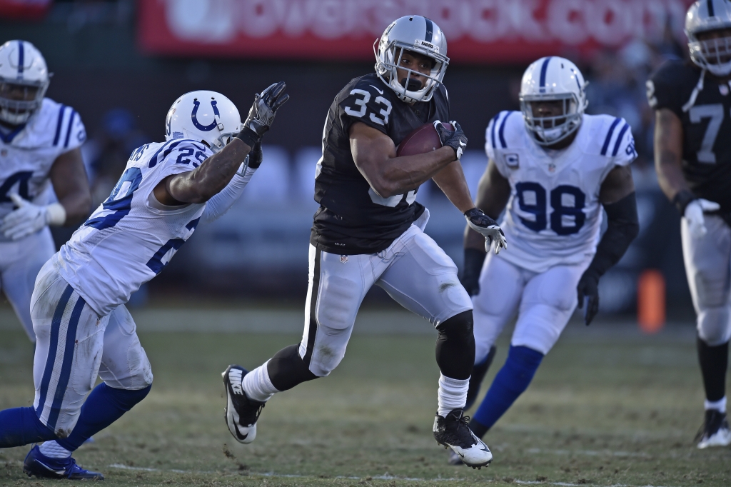 Oakland Raiders De Andre Washington runs with the ball before being tackled by Indianapolis Colts Mike Adams in the fourth quarter of their NFL game at the Coliseum in Oakland Calif. on Saturday Dec. 24 2016. (Jose Carlos Fajardo  Bay Area N