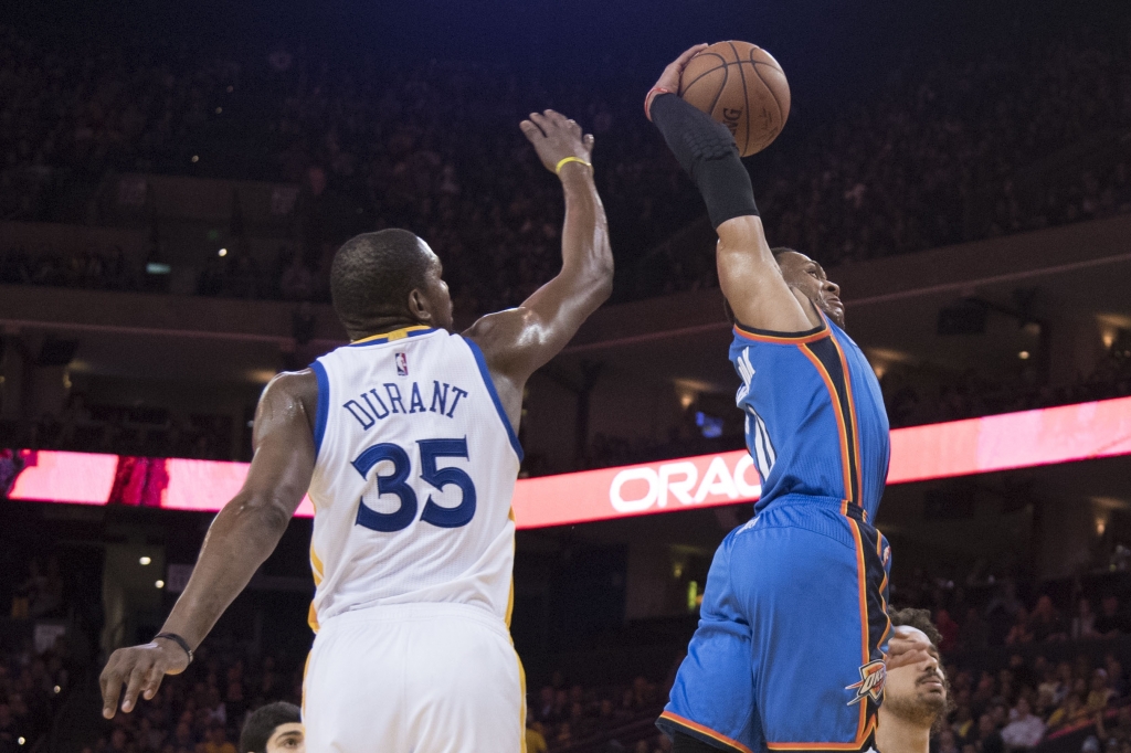 Oakland CA USA Oklahoma City Thunder guard Russell Westbrook dunks the basketball past Golden State Warriors forward Kevin Durant during the third quarter at Oracle Arena. The Warriors defeated the Thunder 121-100. Man