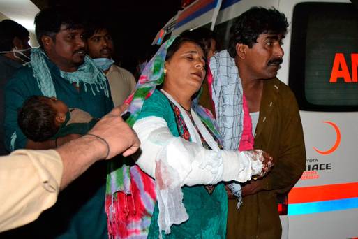 A man help his injured wife after the bombing in Sehwan some 200 kilometres northeast of the provincial capital Karachi