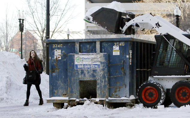 A pedestrian walks past a snow clearing operation Friday Feb. 10 2017 in Boston after the previous day's snowstorm