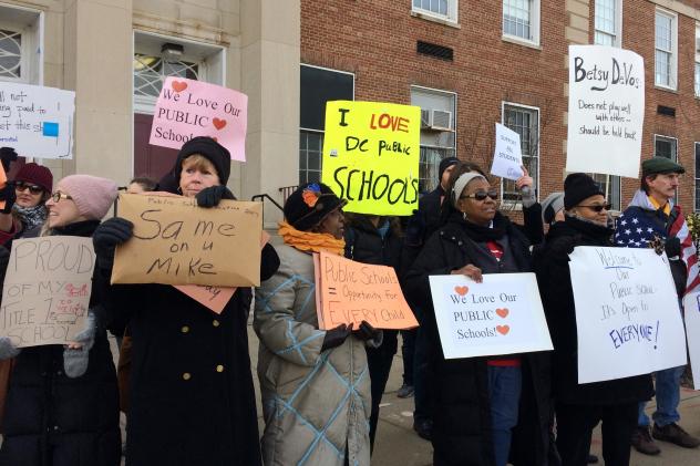 Protesters gather outside Jefferson Middle School in Washington where Education Secretary Betsy De Vos paid her first visit as education secretary