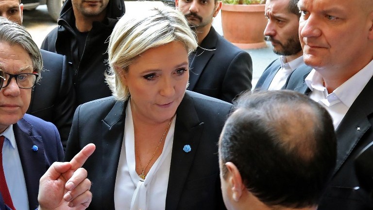 France's far-right presidential candidate Marine Le Pen reacts upon being handed a headscarf ahead of her meeting with Lebanon's Grand Mufti Sheikh Abdul Latif Derian in the capital Beirut