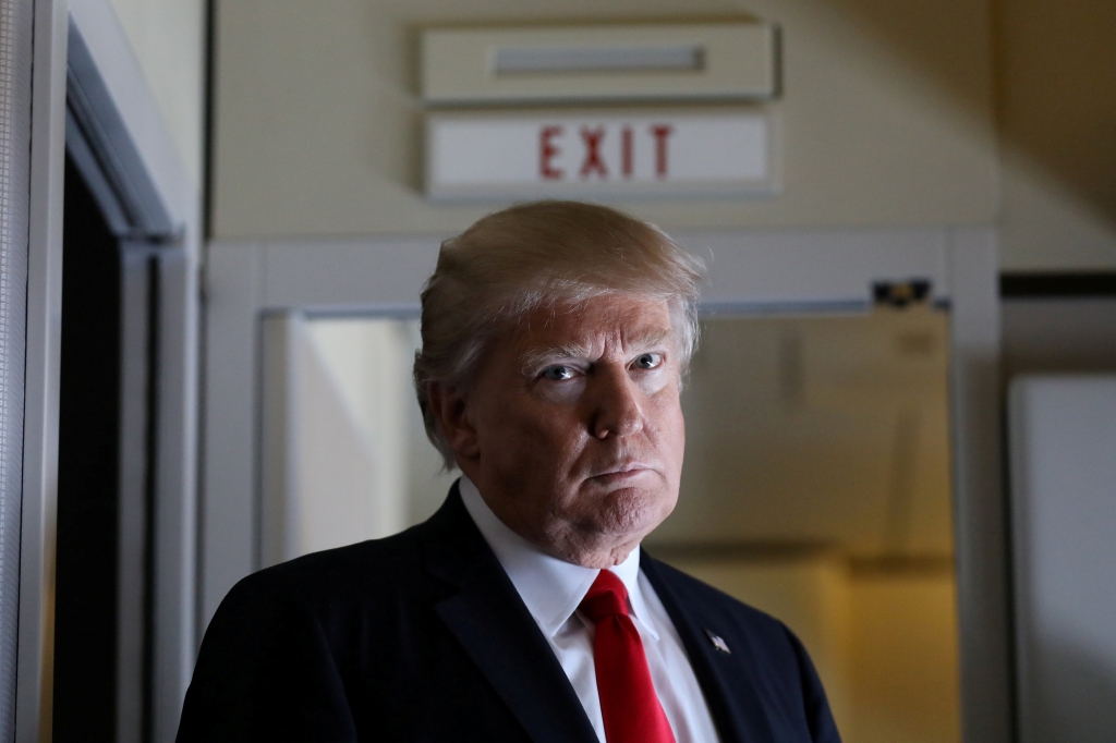 U.S. President Donald Trump pauses as he talks to journalists who are members of the White house travel pool on board Air Force One during his flight to Palm Beach Florida while over South Carolina U.S