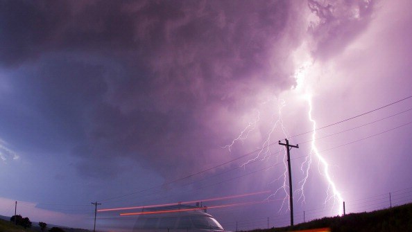 A large lightning bolt strikes behind a storm chaser's moving van. Osage County Oklahoma