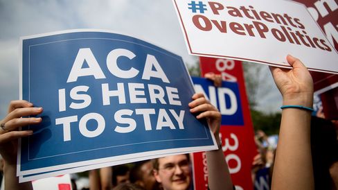 A demonstrator in support of the Affordable Care Act holds up a sign outside the Supreme Court in Washington