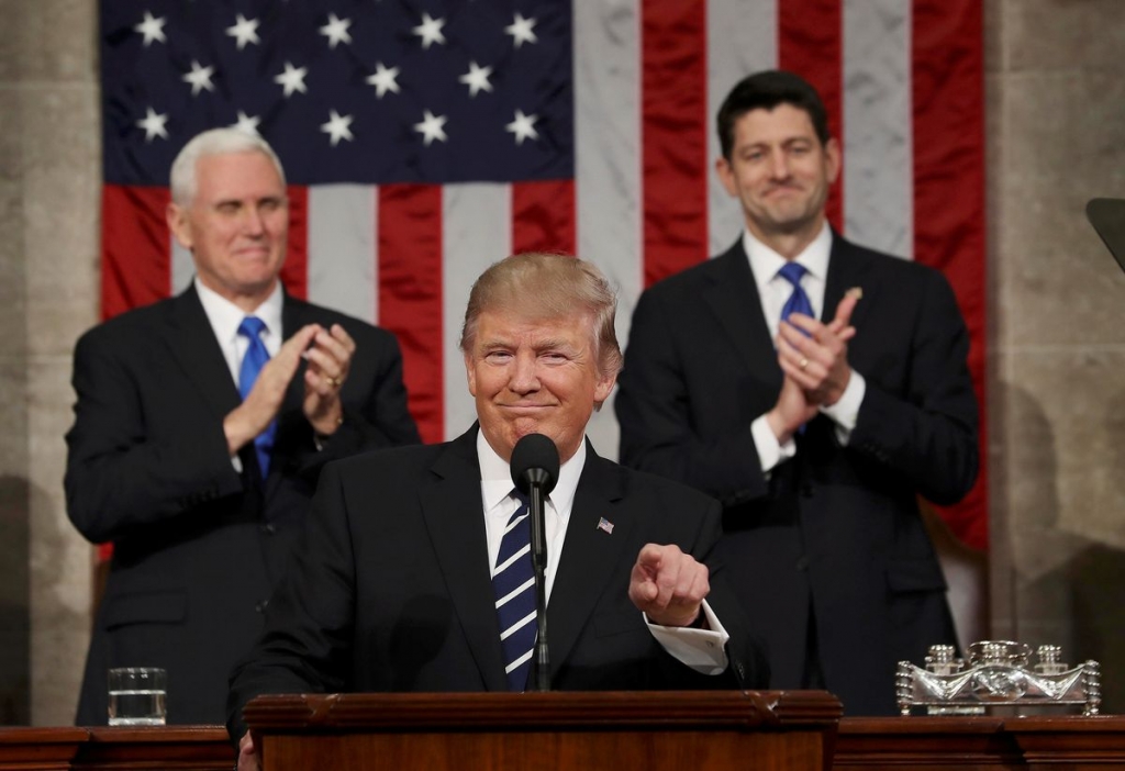 Vice President Mike Pence left and Speaker of the House Paul Ryan right applaud as President Donald J. Trump arrives to deliver his first address to a joint session of Congress from the floor of the House of Representatives in Washington D.C. on Feb