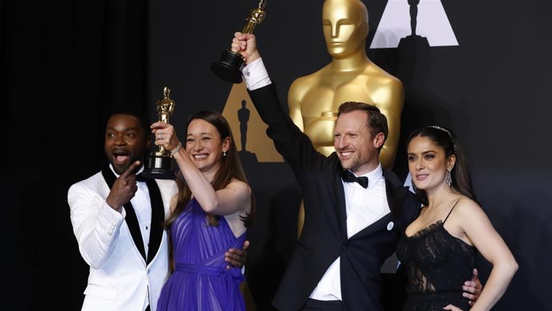 Orlando von Einsiedel and Joanna Natasegara hold their Oscars for Best Documentary Short Subject for The White Helmets as they pose with presenters David Oyelowo and Selma Hayek