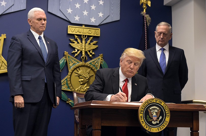 President Donald Trump signs an executive order on Jan. 27 at the Pentagon. The White House said this week that Trump wants to hike defense spending by $54 billion with offsetting cuts in foreign assistance and other non-military spending