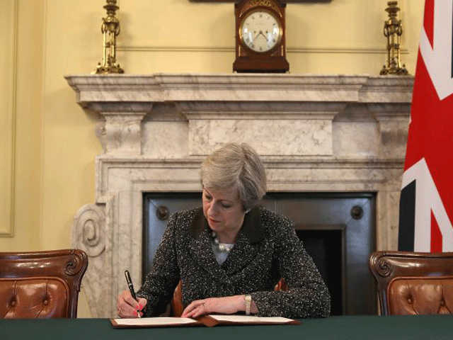 British PM Theresa May in the cabinet office signs the official letter to European Council President Donald Tusk invoking Article 50 and the UK's intention to leave the EU