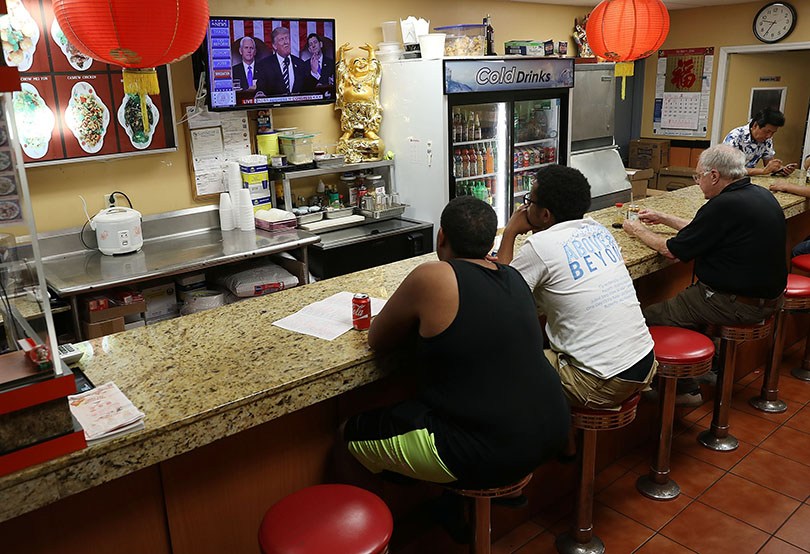 Customers at a Chinese restaurant in Miami watch television Tuesday night as President Donald Trump delivers a speech to a joint session of the U.S. Congress