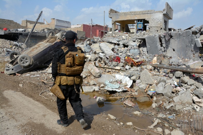 A member of the Counter Terrorism Service walks at the site after an air strike attack against Islamic State triggered a massive explosion in Mosul