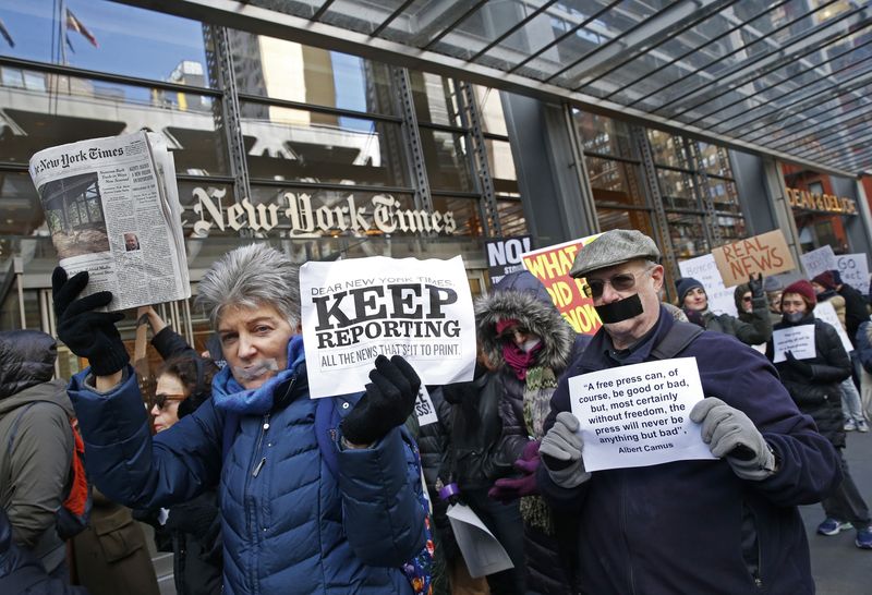 Protesters hold signs and a copy of the New York Times during a rally in front of The New York Times building in New York City on Sunday Feb. 26 2017