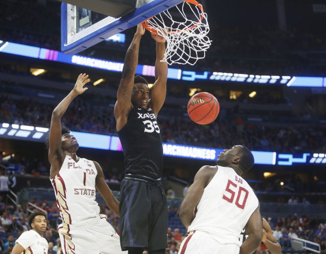 Xavier forward Ra Shid Gaston dunks over Florida State center Michael Ojo ) during the first half at the Amway Center in Orlando